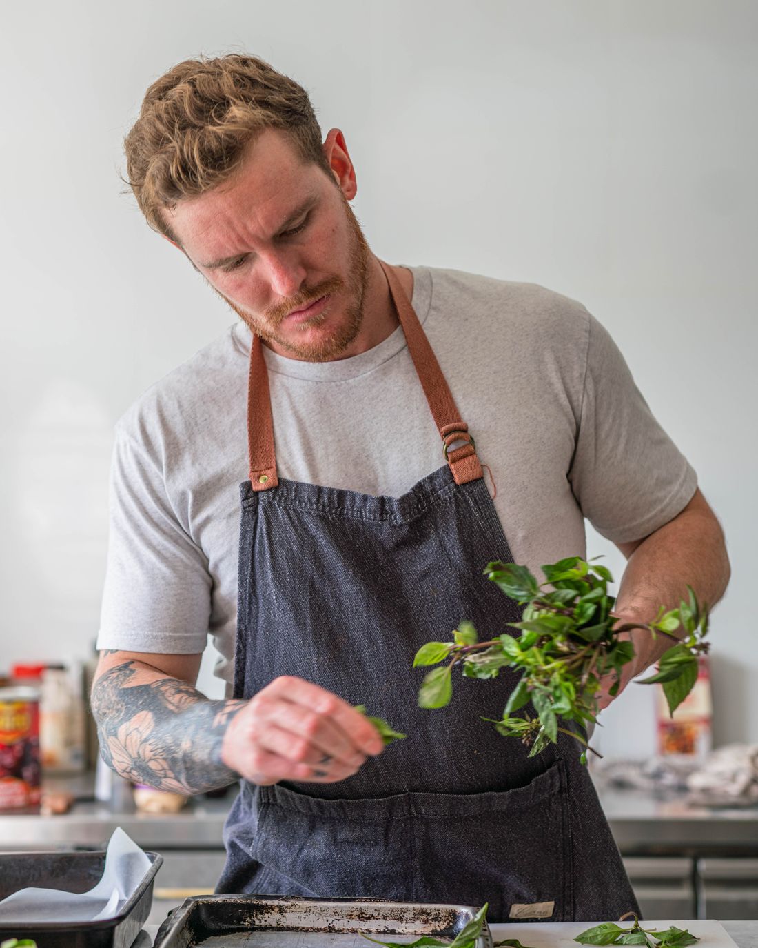 Andrew in his chef's apron picking fresh herbs